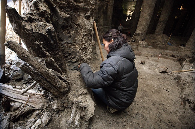 Археологи аккуратно очищают найденные деревянные артефакты 