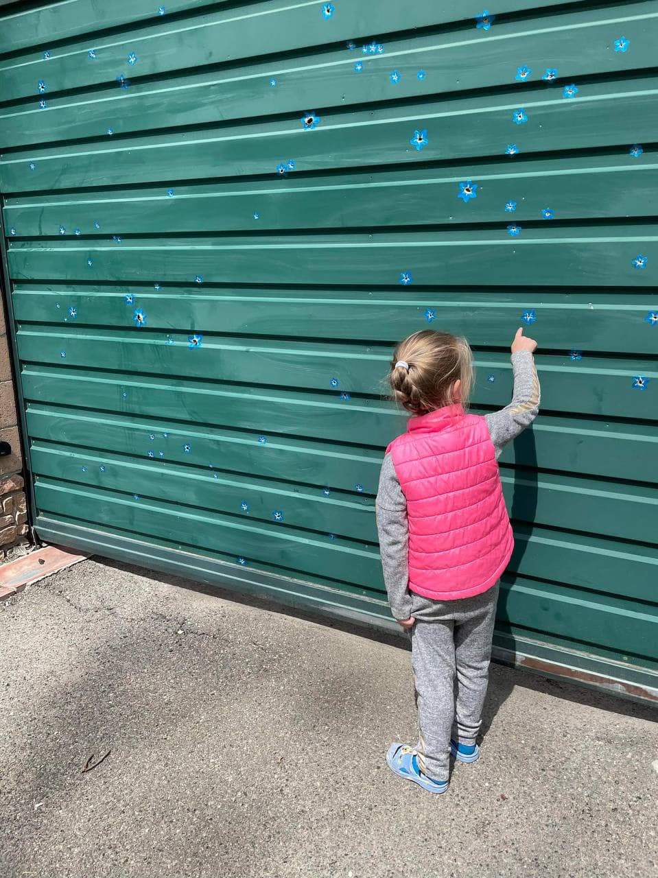 В Буче художница "превратила" отверстия от пуль в цветы (фото)