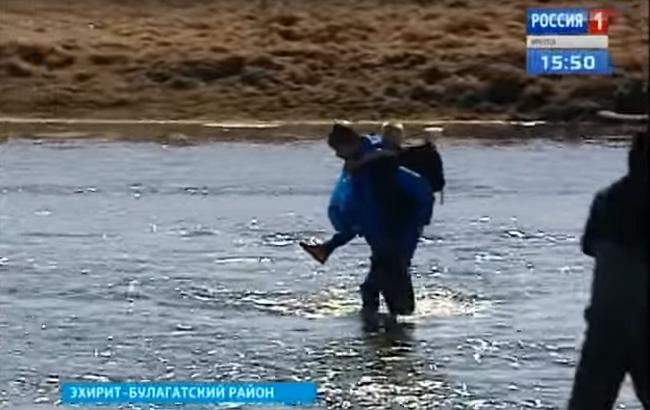 Російські діти добираються до школи через річку на спині у семикласника